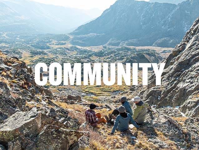 a group of people sitting on the edge of a mountain