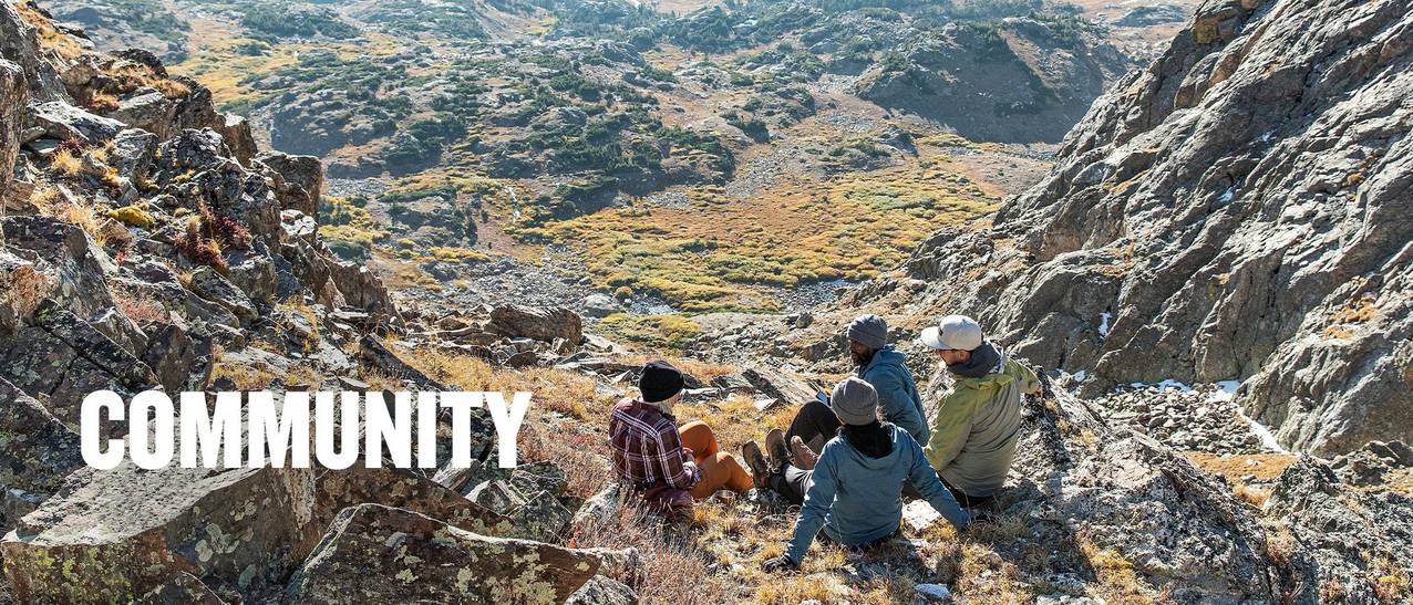 a group of people sitting on the edge of a mountain