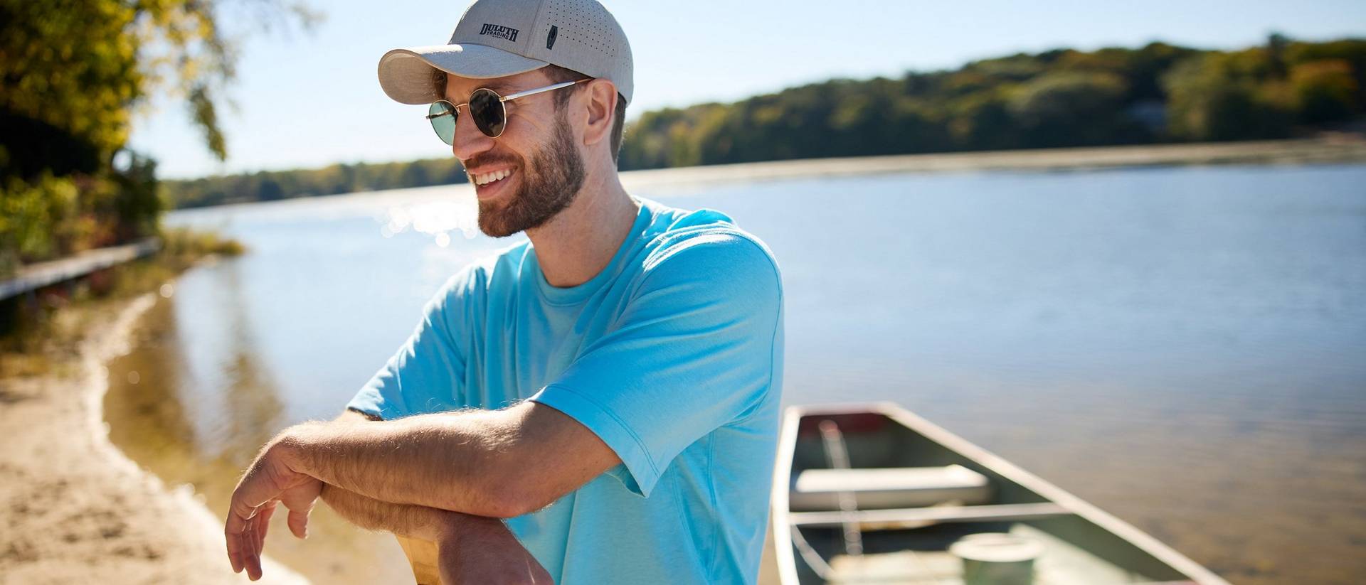 Man in blue shirt near canoe.