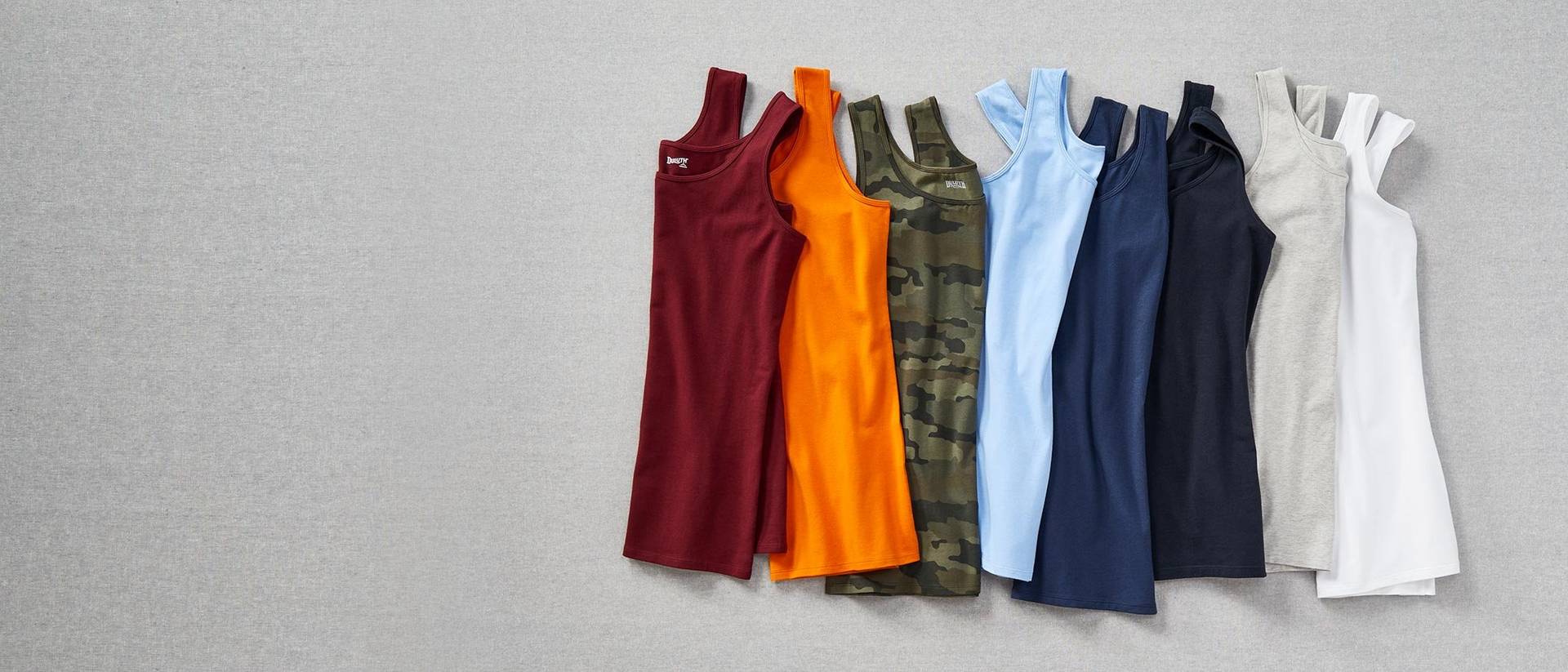 tank tops in various colors laying on a gray fabric background