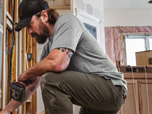 Man wearing grey t-shirt, crouching down
