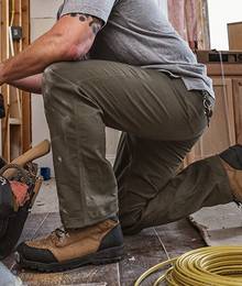 A close-up of Fire Hose pants on a man kneeling while working