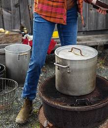 A woman in jeans stands by a grill 