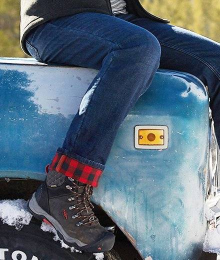 Close up of the rolled-up cuff of jeans showing the plaid lining