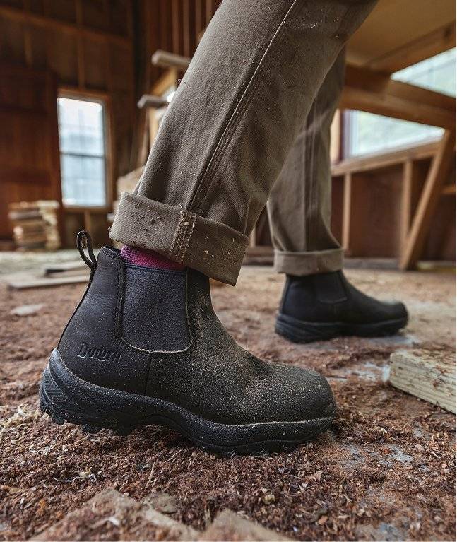 Woman wearing black chelsea boots.