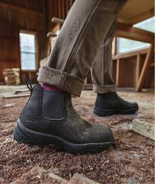 Woman wearing black chelsea boots.