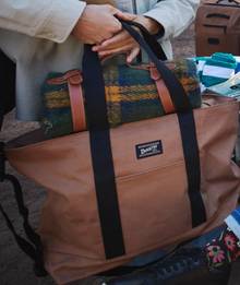 Woman carrying large canvas tote bag.