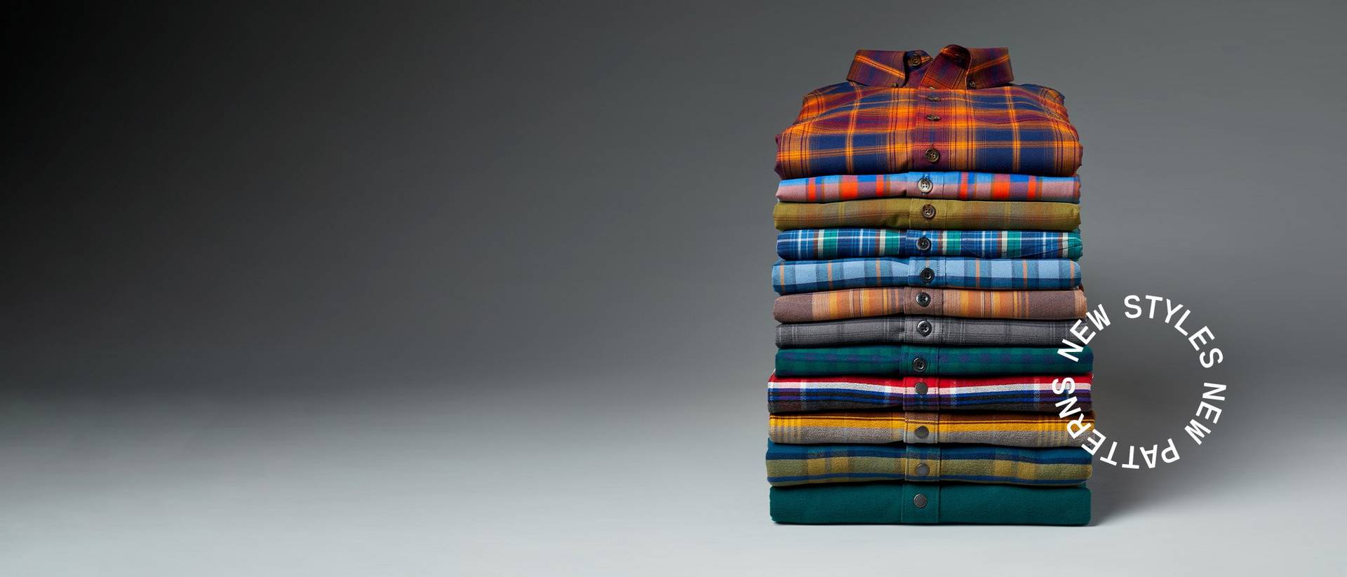 a stack of neatly folded flannel shirts in various colors