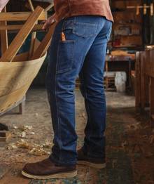 Man woodworking in jeans.
