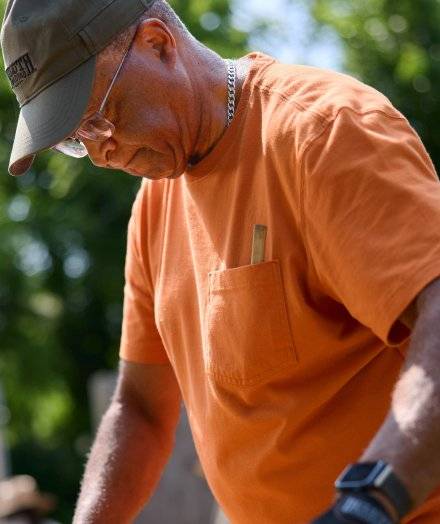 Man wearing orange Longtail T® with pocket.