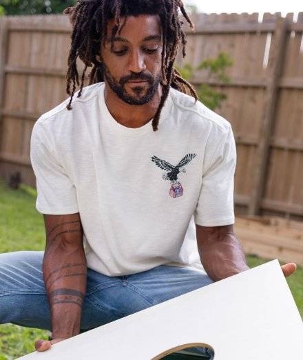 Man wearing white tee with eagle on it.