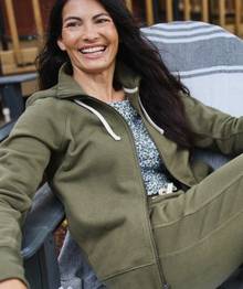 Woman wearing olive green loungewear, smiling.