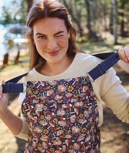 Woman wearing purple patterned overalls.