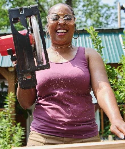 Woman wearing purple tank top, smiling.