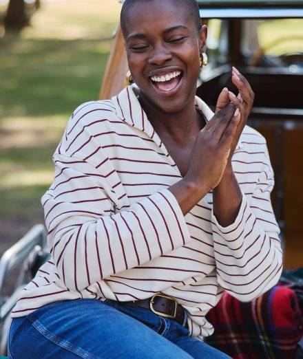 Woman wearing striped sweater, smiling.