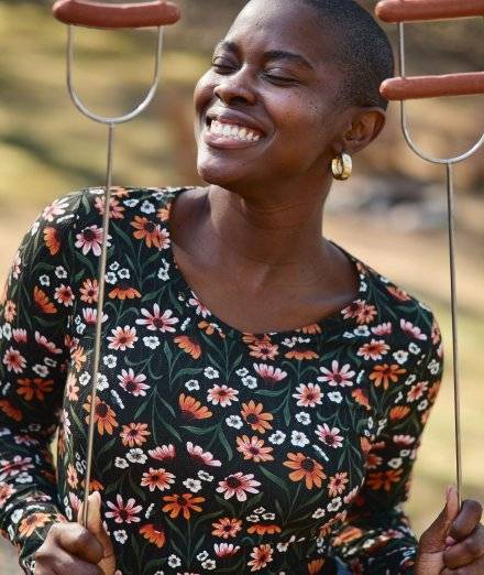Woman wearing floral shirt, smiling.