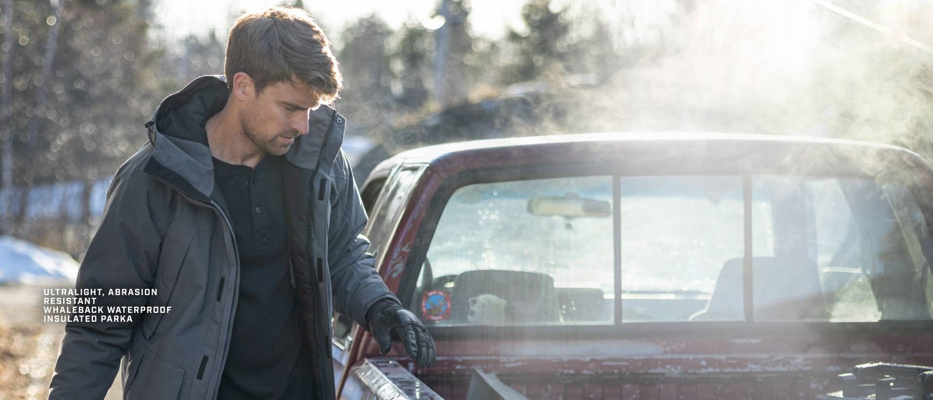 Man wearing a blue winter jacket, standing by truck
