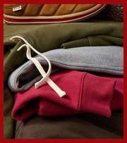 Sweatshirts and sweatpants folded into a pile.