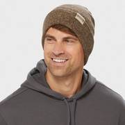 Man wearing a brown fold over beanie, smiling.