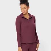 Woman wearing a maroon loungewear set.