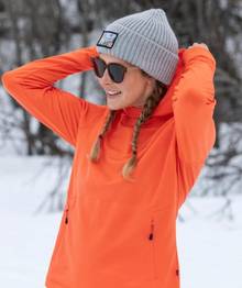 Woman wearing an orange fleece top.