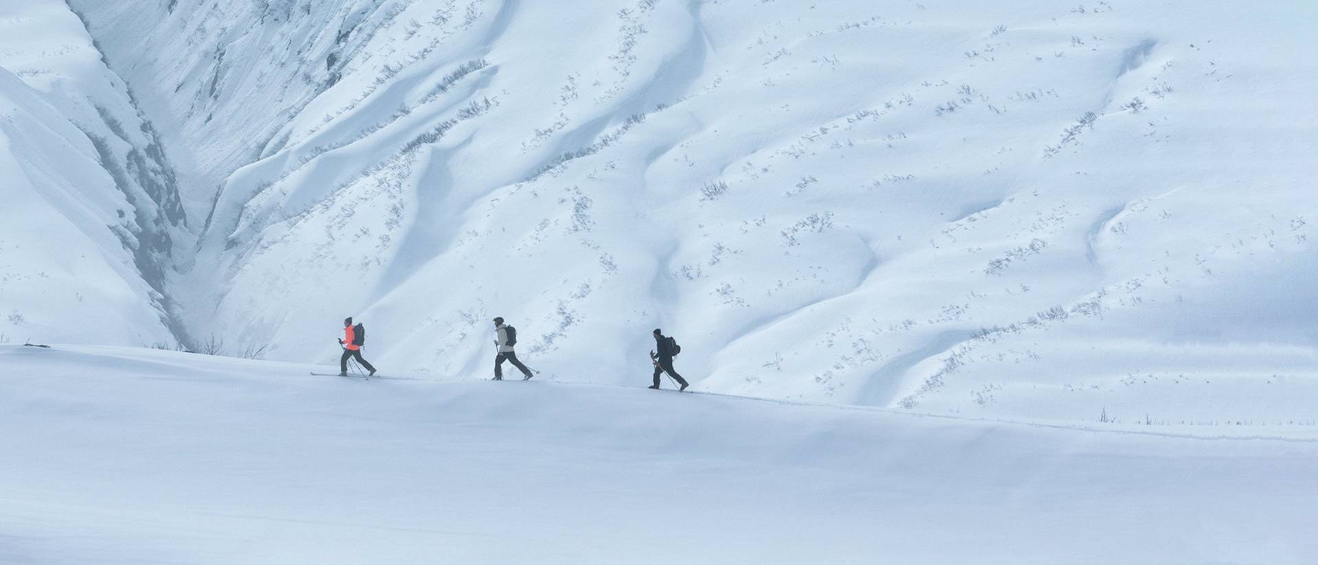 Three people hiking on a snowy mountain.