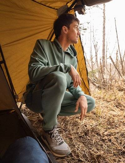 Man wearing a green sweatshirt and sweatpants.