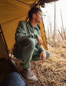 Man wearing a green sweatshirt and sweatpants.