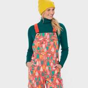 Woman wearing holiday tree patterned overalls.