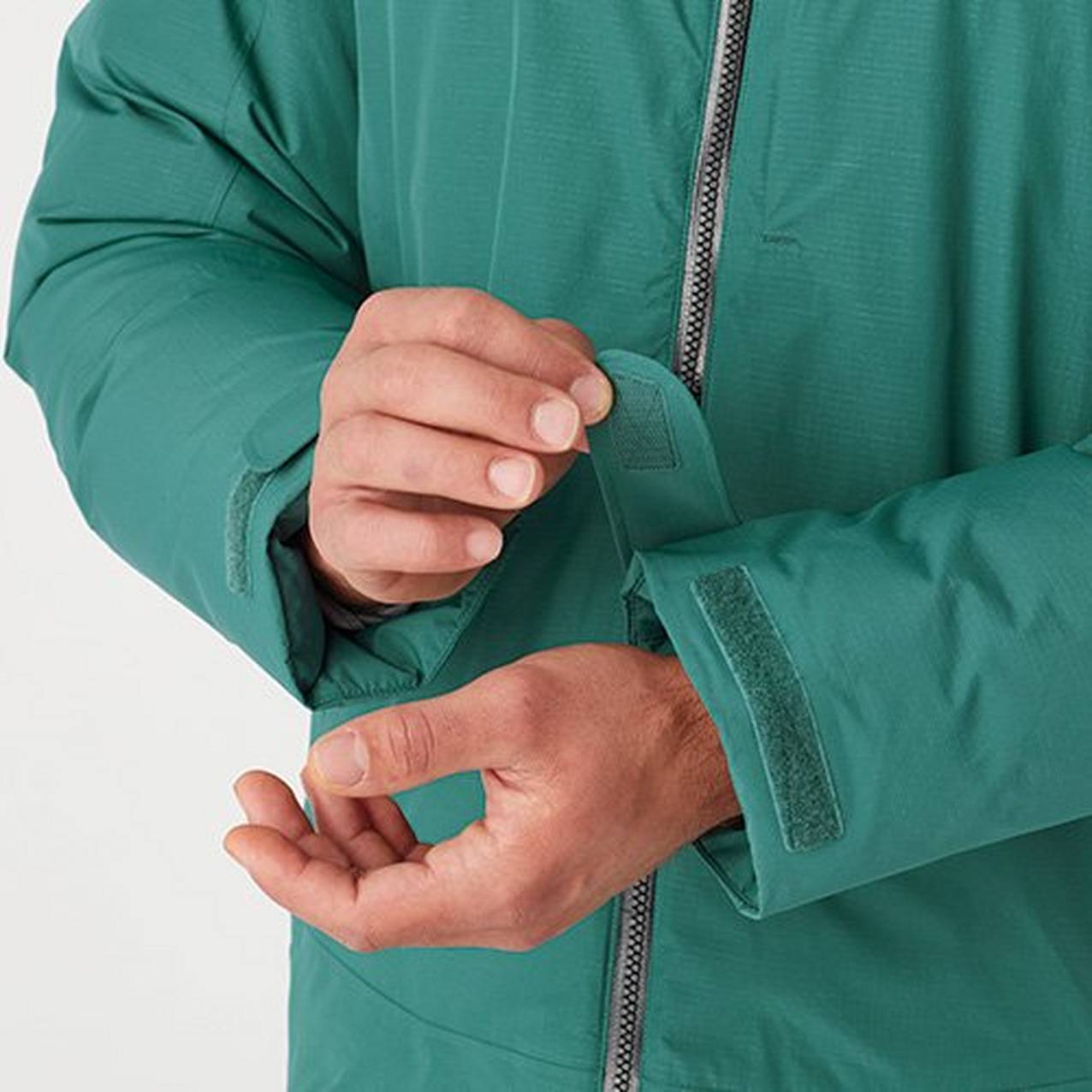 Close up of a hand adjusting the velcro cuff of a jacket