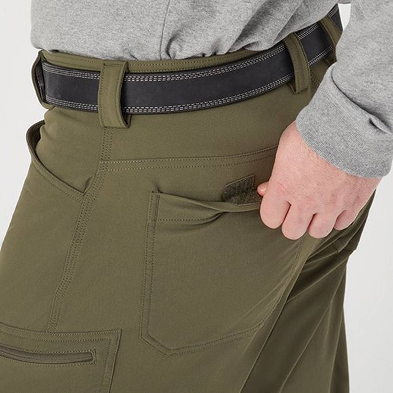 Close up of a hand opening the back pocket of pants to show a hook and loop closure of the pocket