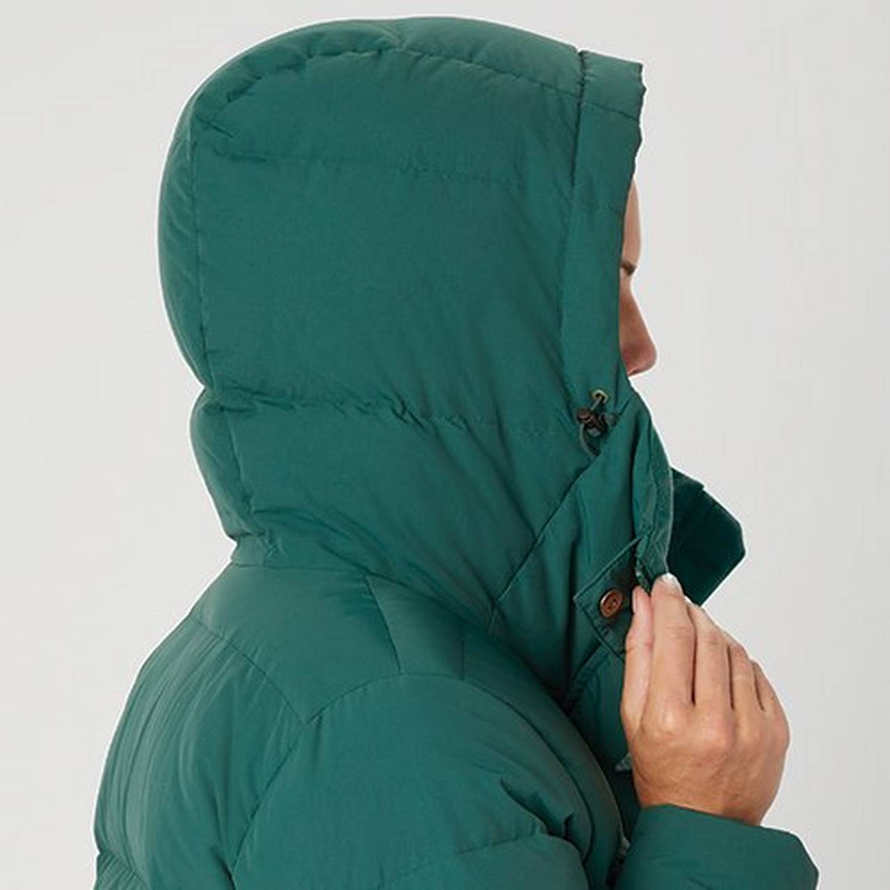 Close up of a woman wearing the hood of a puffy jacket