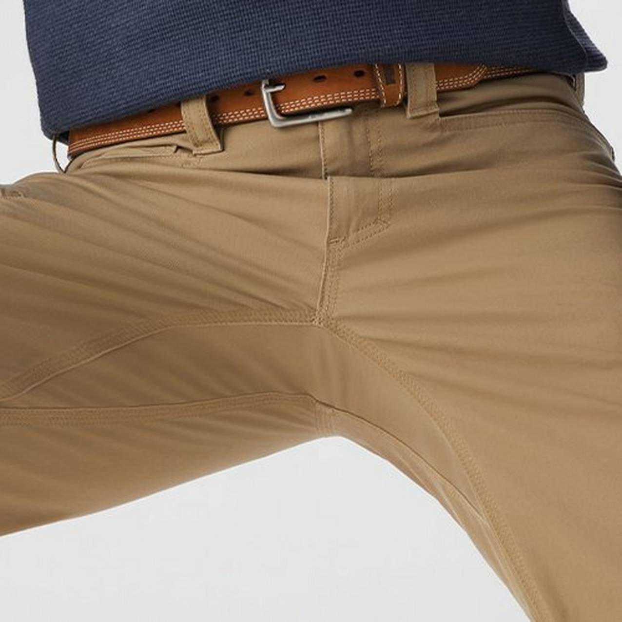 Close up of a man crouching in pants to show the range of motion