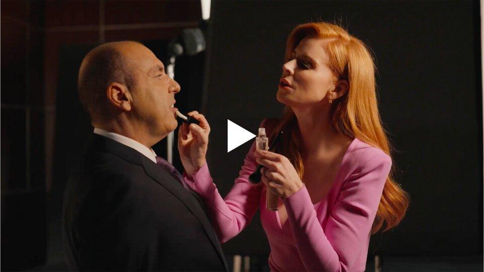 Sarah Rafferty, the stenographer, applying lip oil on Rick Hoffman the plaintiff