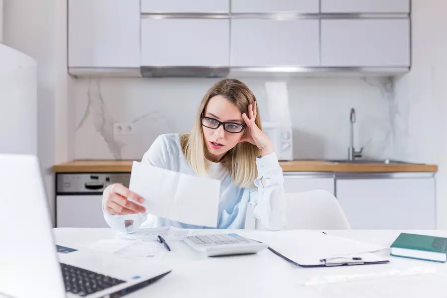 housewife sitting table house kitchen incomprehensible deal with paperwork bills loans