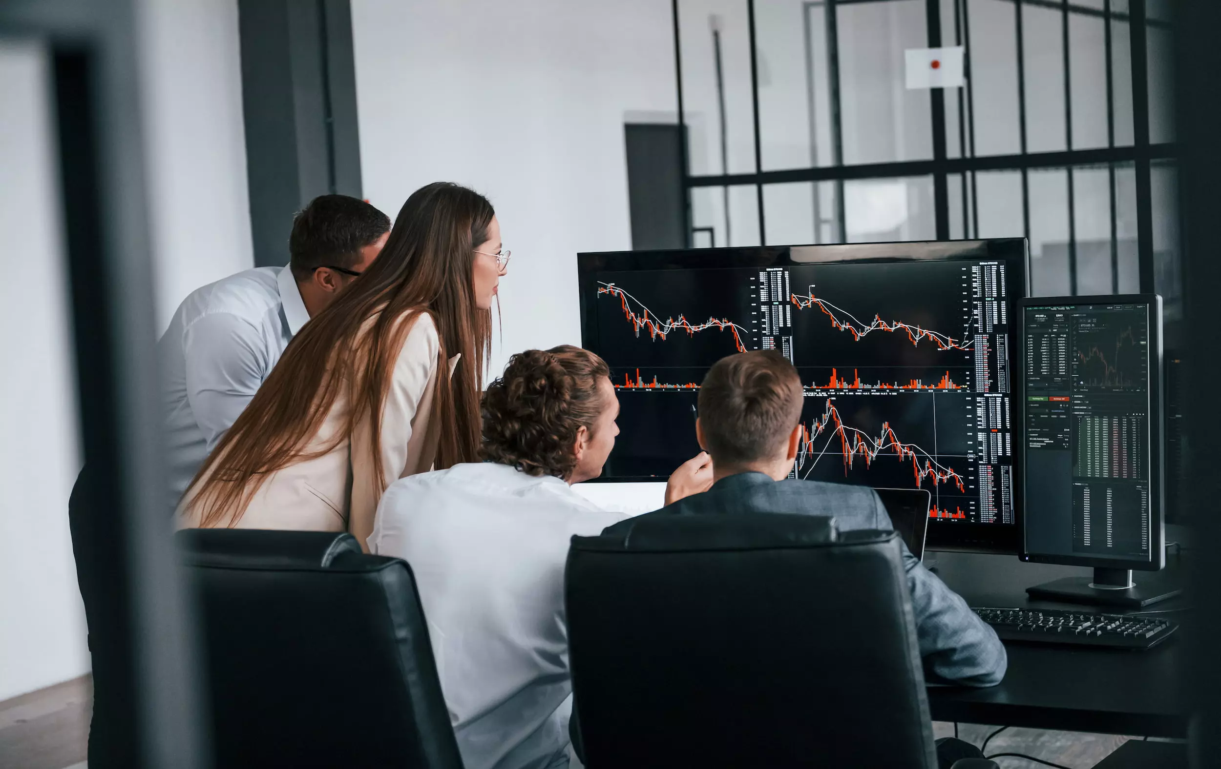 tracks graphs team stockbrokers works modern office with many display screens