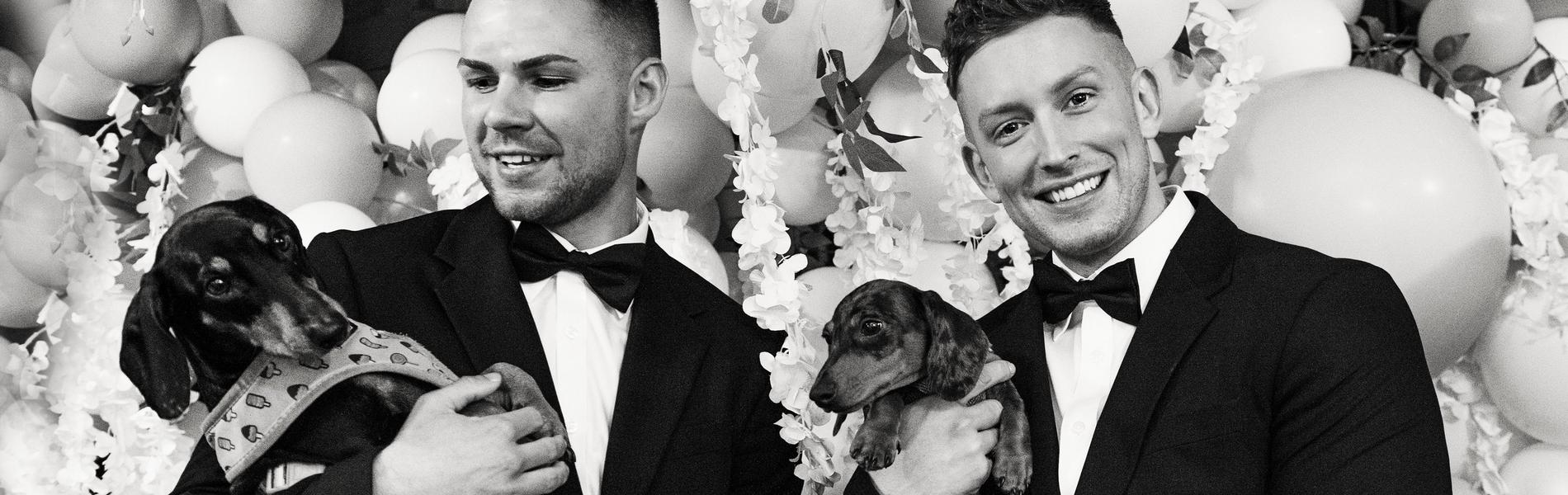 Groom and Groom holding dogs