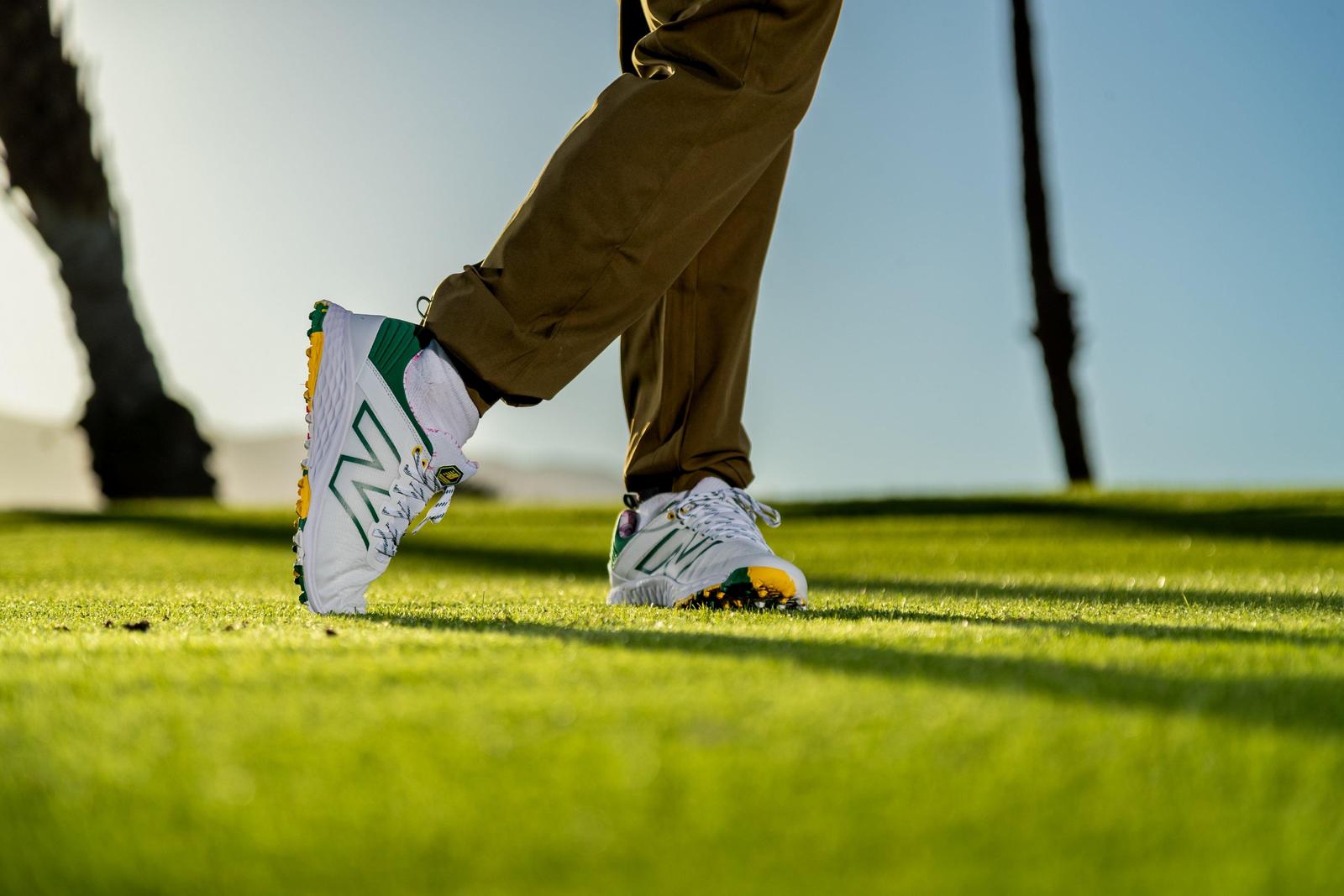 a person's feet are on the grass while they are playing golf