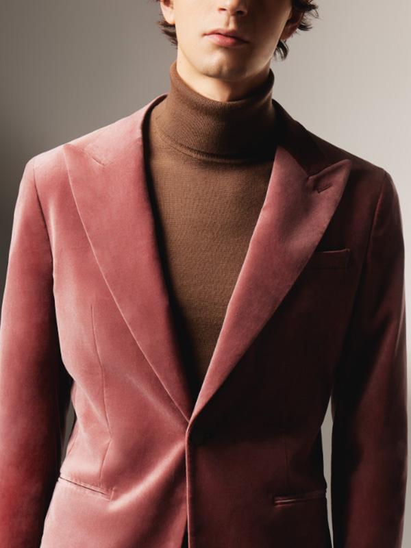 Man in brown roll neck jumper with brick coloured blazer