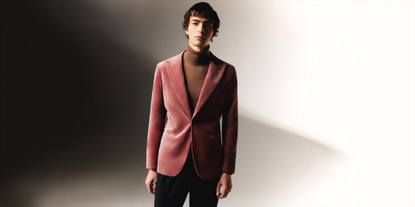 man in a brock coloured blazer and brown roll neck