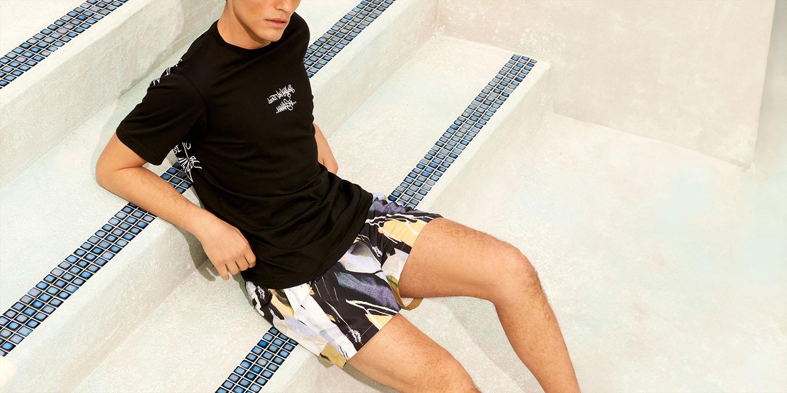 Man sitting in an empty pool with summer outfit on