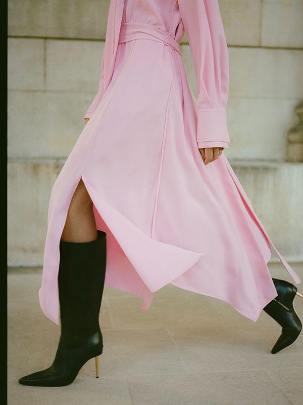woman wearing a pink flowy dress and black knee high boots