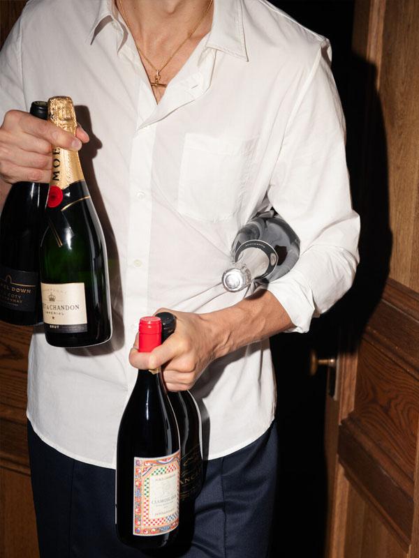 man holding two bottles of wine