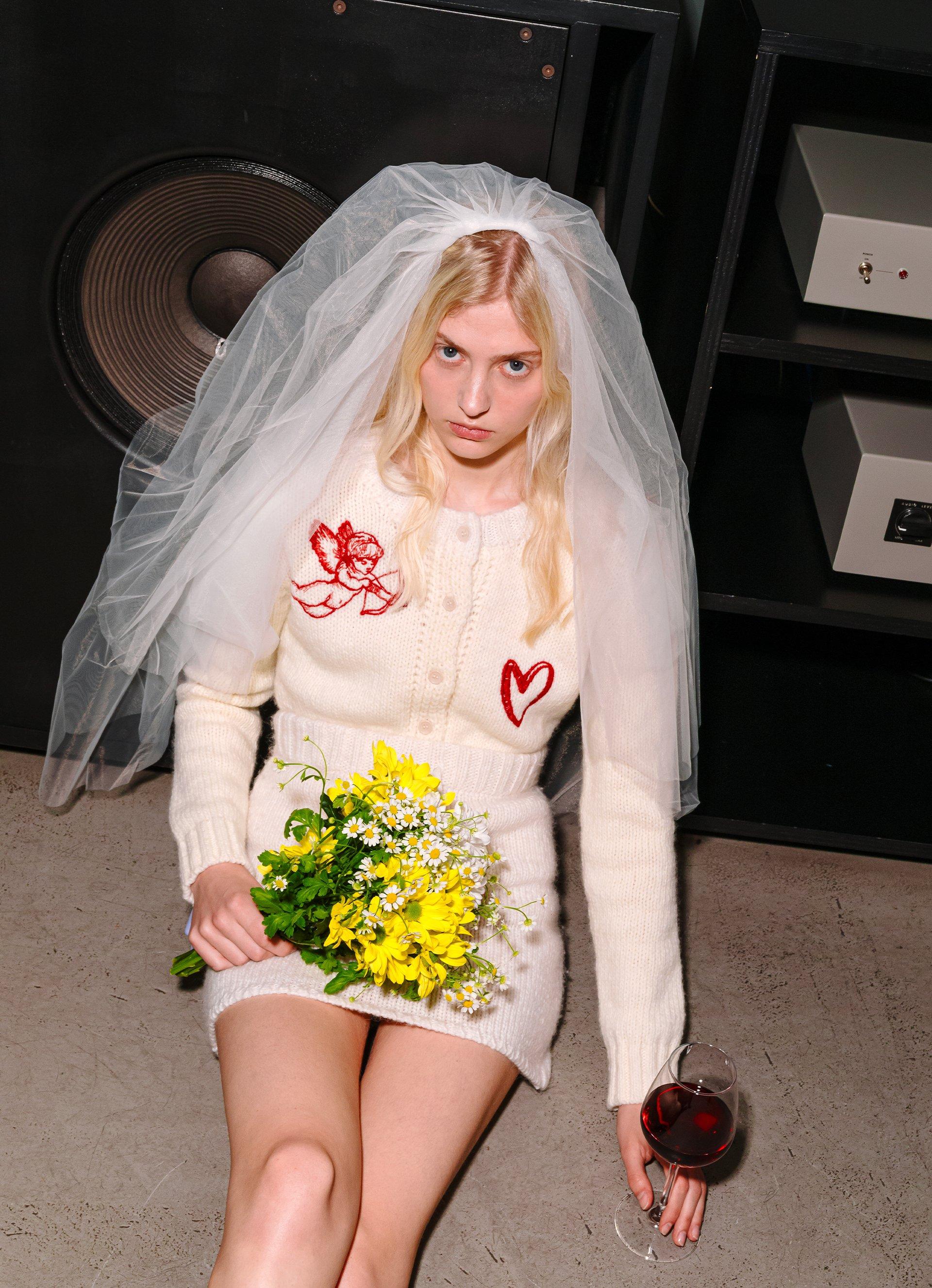 Models wear the Cupid Knit Cardigan in Cream and the Embroidered Knit Mini Skirt in Cream.