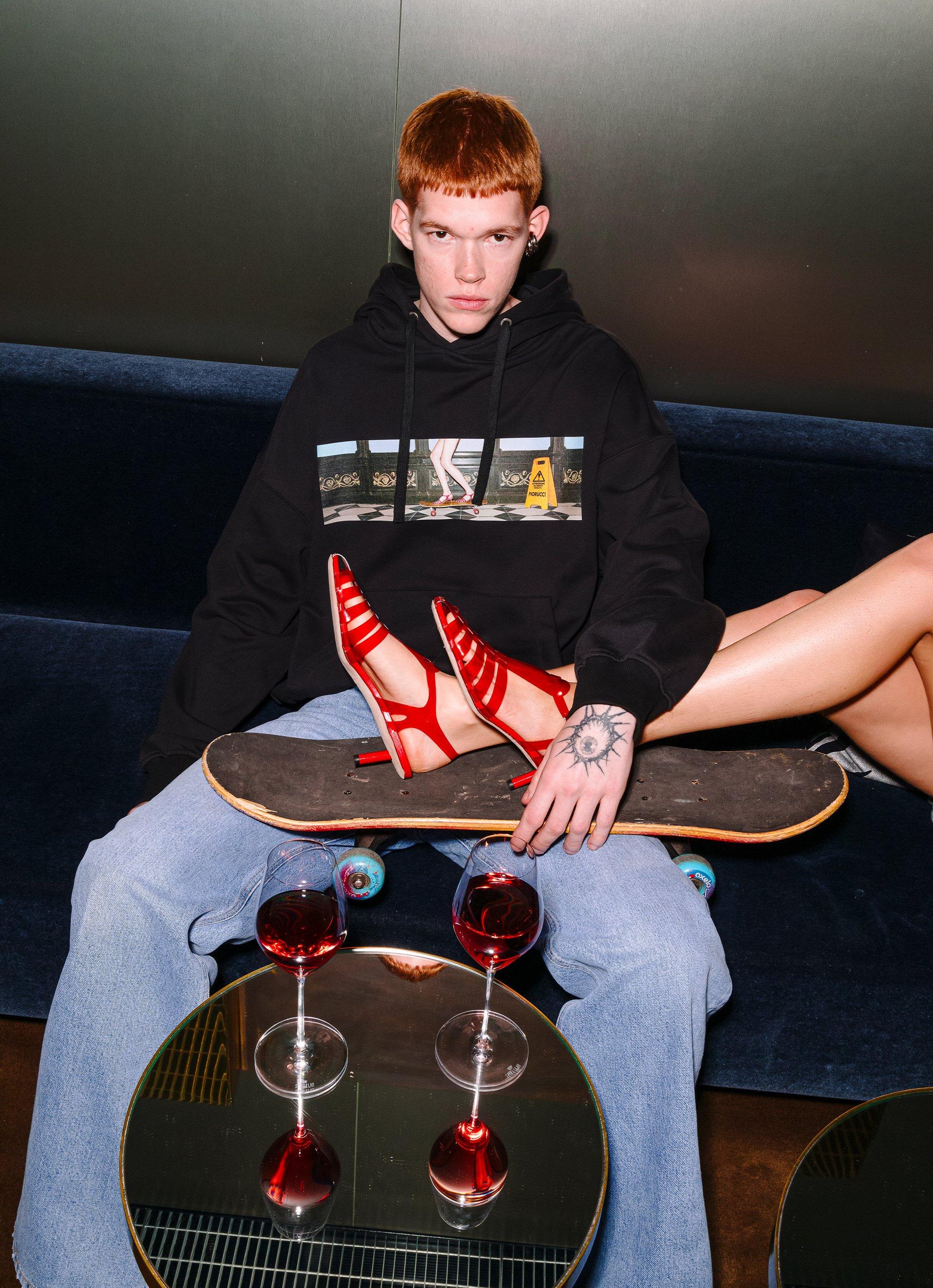 Model wears the Skateboard Print Hoodie in Black and the Made In Heaven Straight Fit Jeans in Mid Blue.