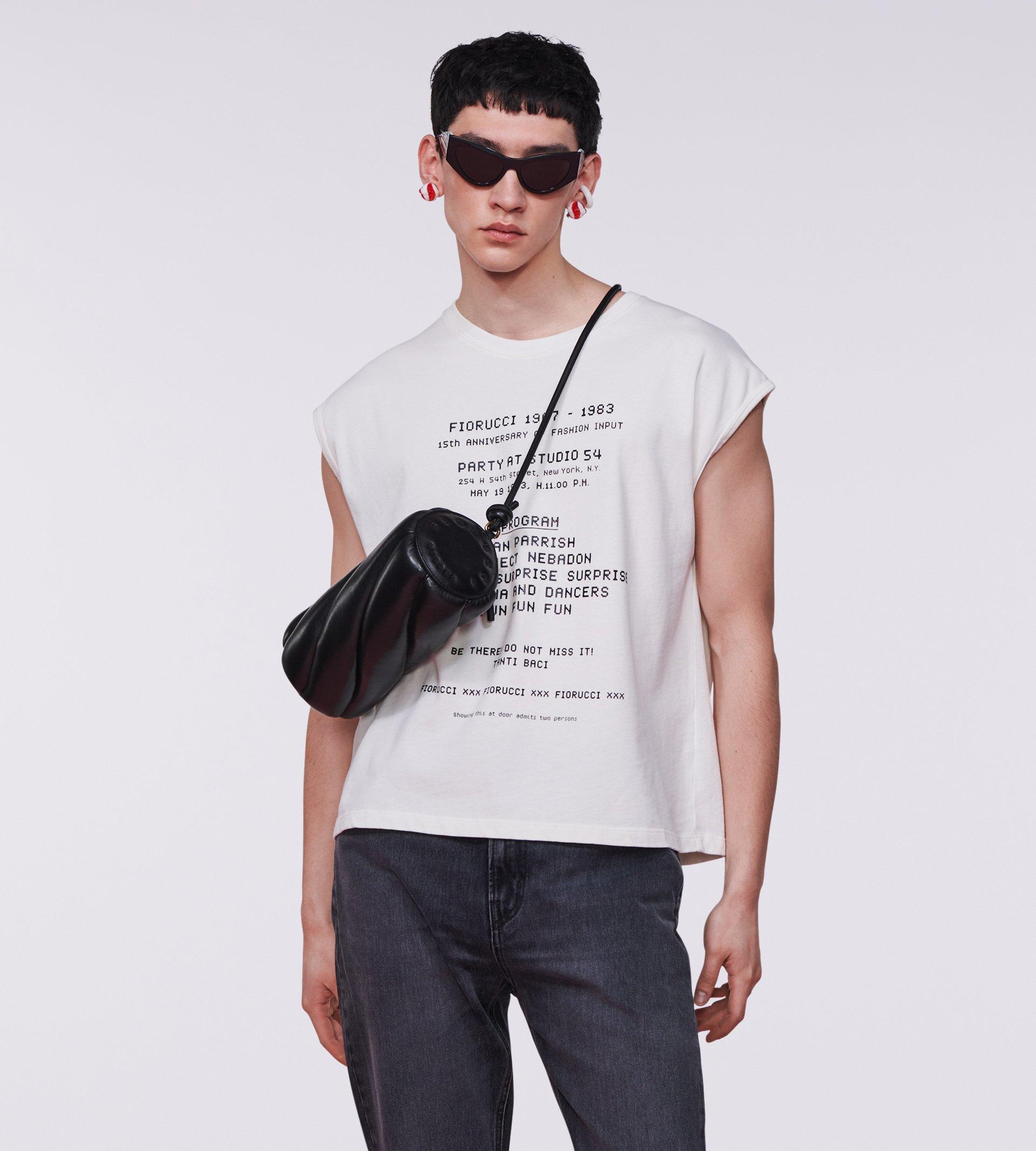 Model wearing the Invitation Graphic Tank Top in White and the Mella Leather Bag in Black.