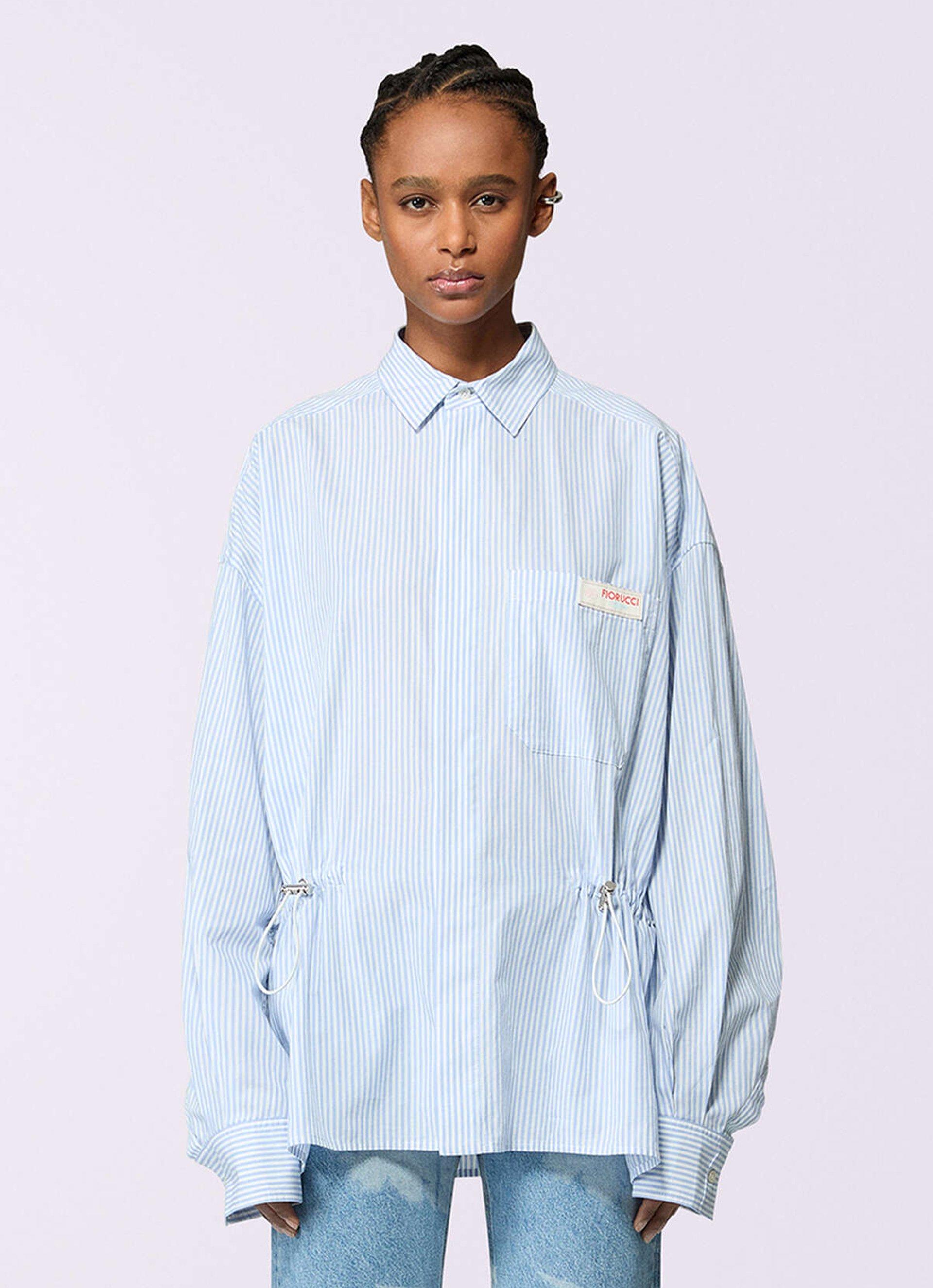 Model wears Unisex Label Patch Stripe Shirt in blue.