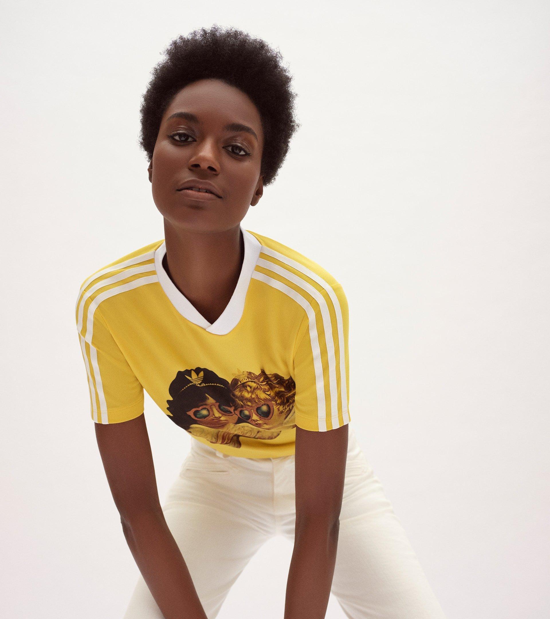 Model wearing the Adidas x Fiorucci Angels Graphic T-Shirt in yellow.