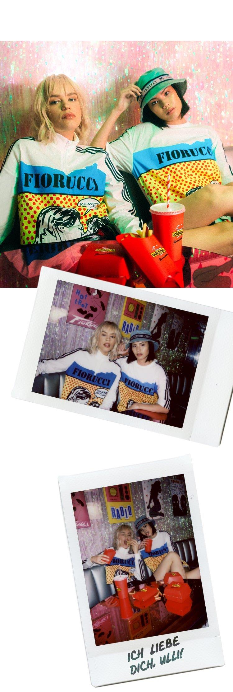 Models wearing the Adidas x Fiorucci Love Print Crop Track Top in white and the Adidas x Fiorucci Love Print T-Shirt in white.