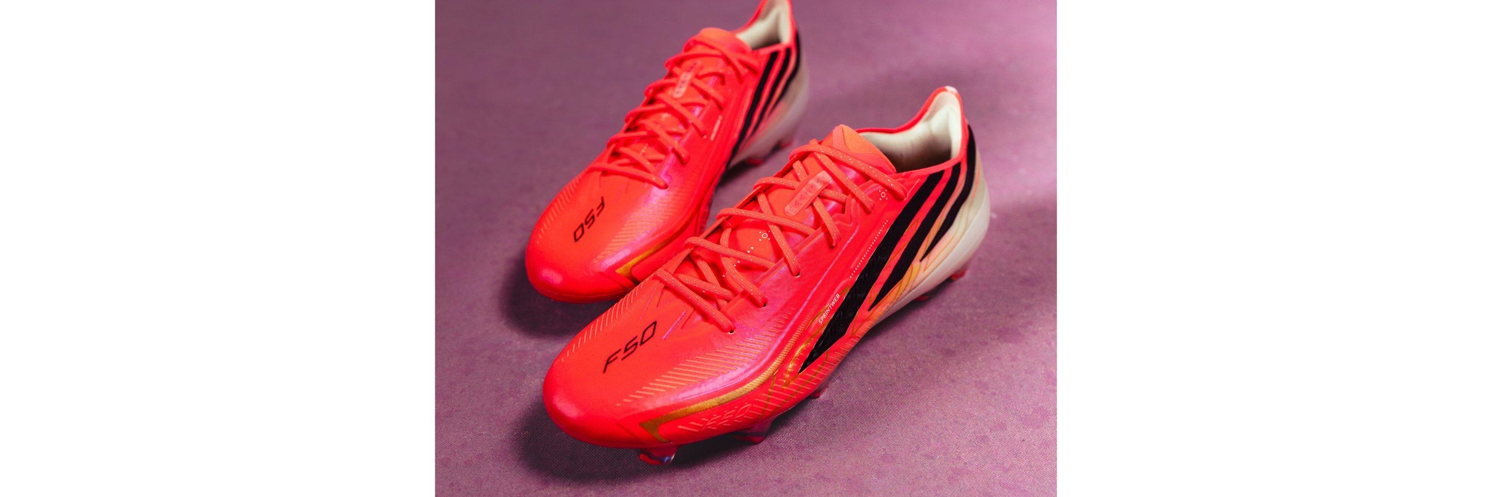 Red adidas football boots on a purple background